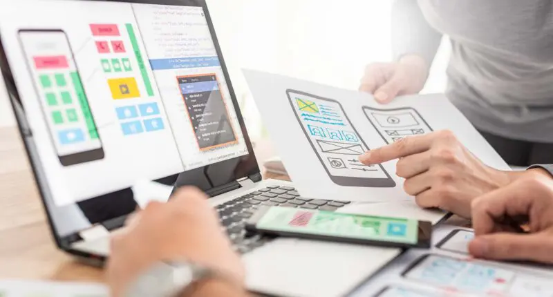 ui ux design review on paper and laptop